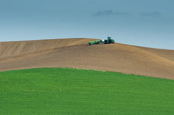 Tractor y sembradora trabajando en una granja — Foto de Stock