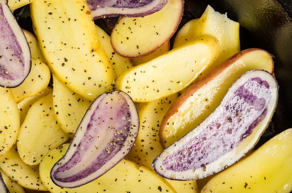 Blaue und gelbe Kartoffeln in einer Pfanne — Stockfoto