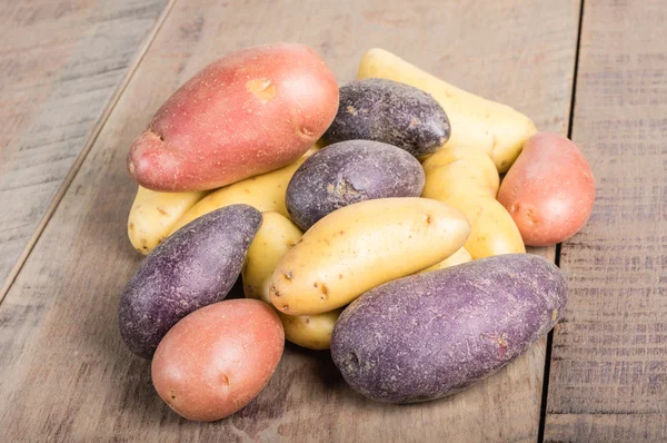 Groep van fingerling aardappelen op houten tafel — Stockfoto