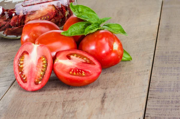 Fresh red paste tomatoes with jar — Stock Photo, Image