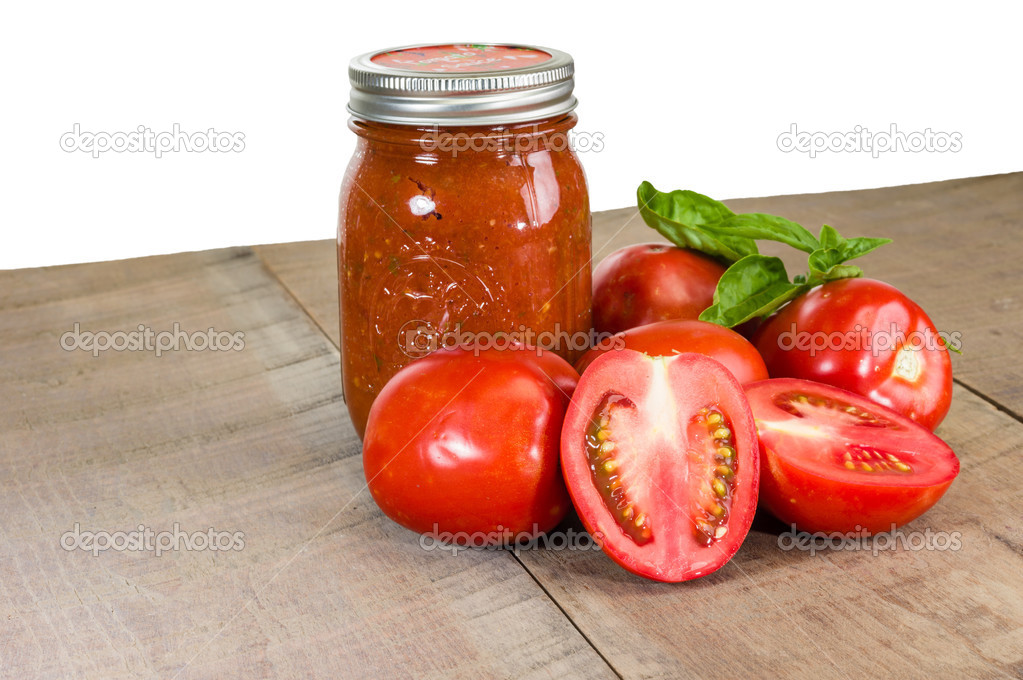 Jar of tomato sauce with tomatoes and basil