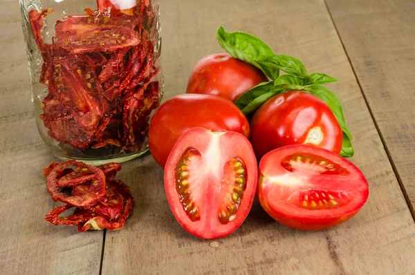 Fresh red paste tomatoes with basil and jar — Stock Photo, Image