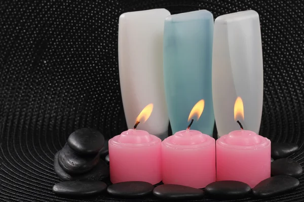 Tubo de plástico com spa pedras pretas e velas — Fotografia de Stock