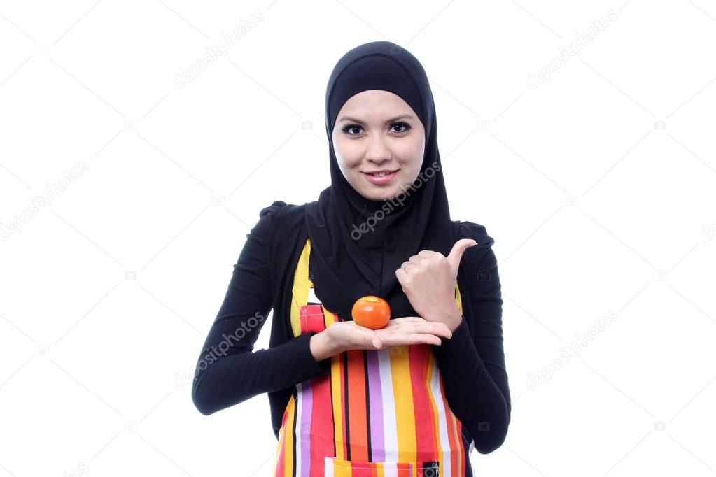 Young muslim shown tomato is good for health. diet concept