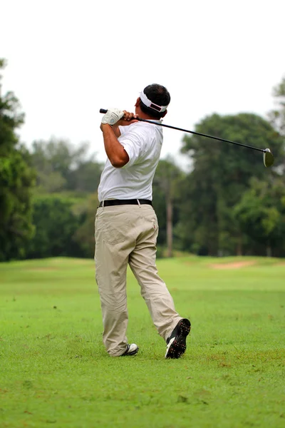 Aziatische mannelijke golfspeler tee off golfbal uit tee vak Rechtenvrije Stockfoto's