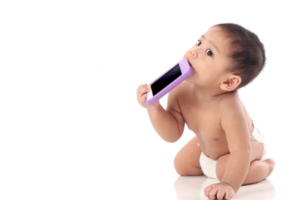 Glad lilla asiatiska baby försöker äta mobiltelefon med text utrymme, — Stockfoto