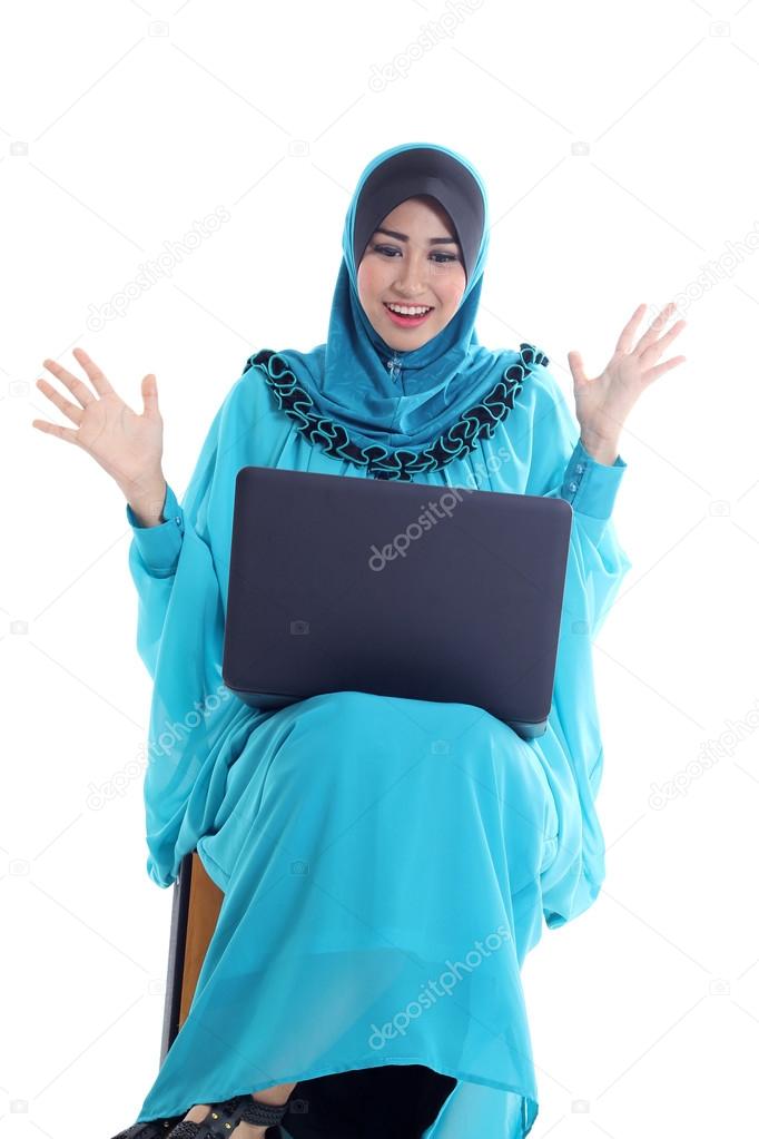 Surprised young muslim woman using laptop isolated on white
