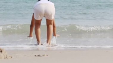 Kumsalda oynarken mutlu