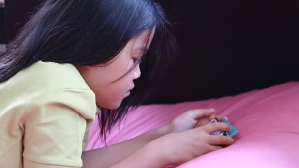 Дівчина грає в ігри на мобільному телефоні — стокове відео