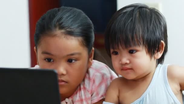 Irmã e jovens à procura de computador em casa — Stok video