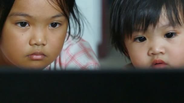 Sister and young looking computer at home — Stock Video