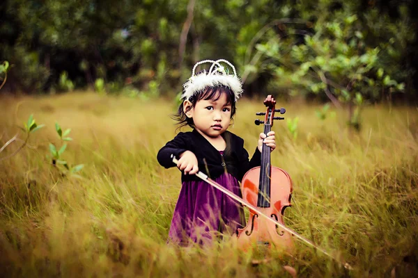 Crianças tocam violino em arbustos Fotografias De Stock Royalty-Free