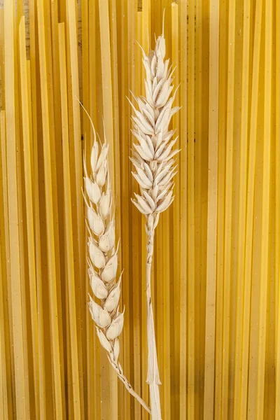 Raw pasta with wheat ears — Stock Photo, Image