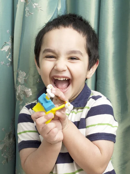 Портрет счастливого маленького мальчика, который тяжело смеется. Стоковое Фото