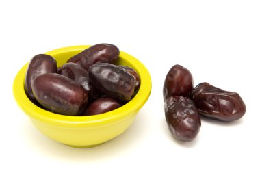 bir kase beyaz arka planda kurutulmuş tarihleri