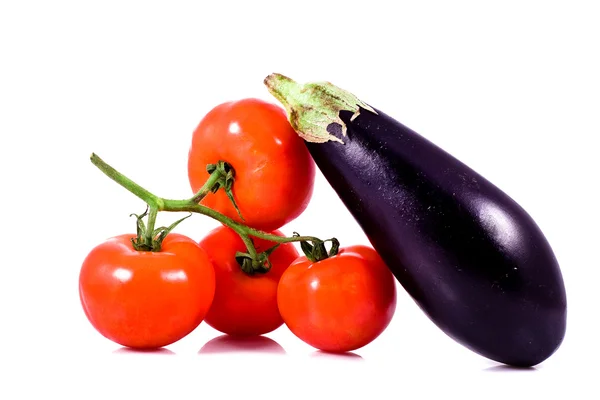 Färska röda tomater på gäng och aubergine — Stockfoto