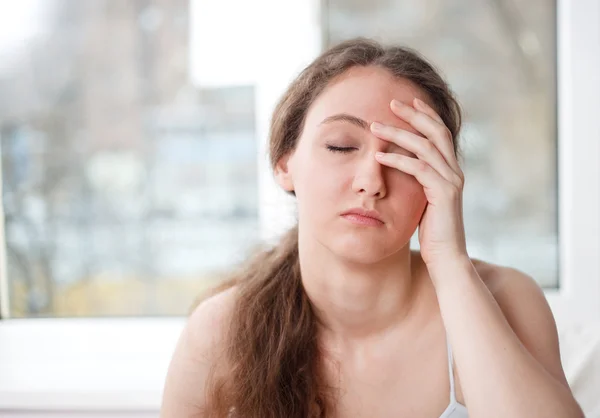 Portrait of a tired young girl, window in the background — Stock Photo, Image