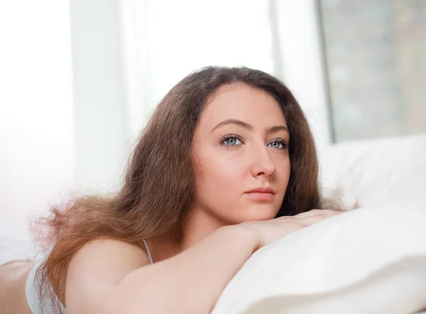 Portrait of a young girl lying in the light room and dreaming — Stock Photo, Image