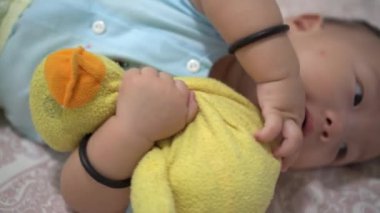 Bebeğin elini kapat, yaşlı peluş ördeği tut.