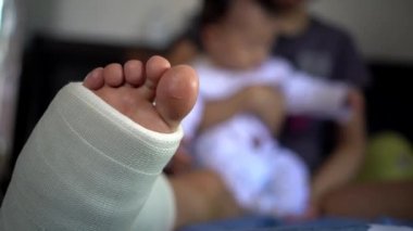 Asyalı anne yatak odasında bebeğe bakıyor.