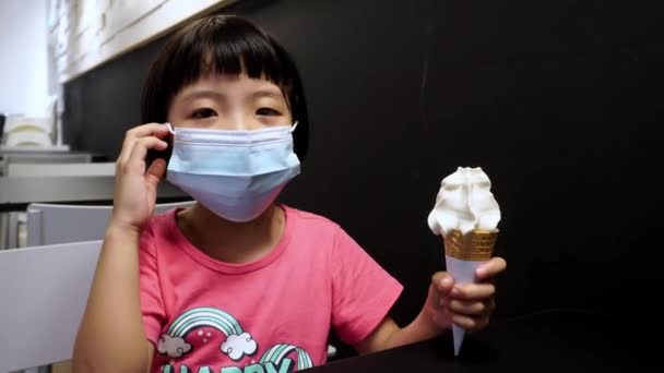 Kleines Mädchen Nimmt Die Gesichtsmaske Und Genießt Eis — Stockvideo