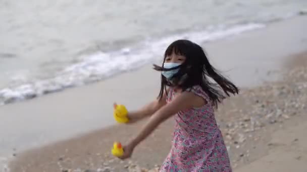 Китайская Девочка Счастливо Играет Жёлтую Резиновую Утку Пляже Пандемия Covid — стоковое видео