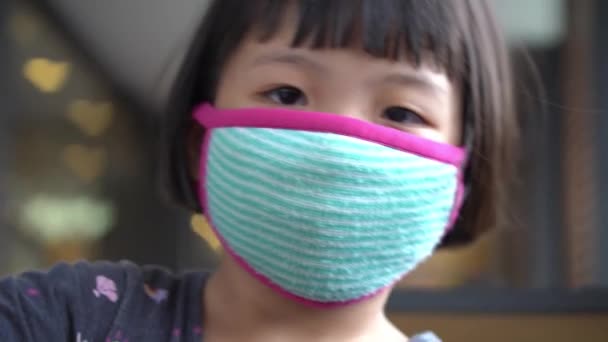 ファブリックフェイスマスク付きの選択的フォーカス小さな子供の顔 コロナウイルス発生時の新しい正常パンデミック — ストック動画