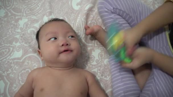 Schwester Spielen Rassel Kleinen Jungen Säugling Gähnt — Stockvideo