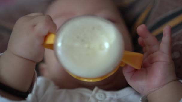選択的フォーカス赤ちゃんの手はベッドでミルクを飲むためにボトルを保持します — ストック動画