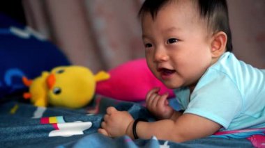 Bir bebek gülüşü Yatağa uzandı Parmağını ağzına koydu