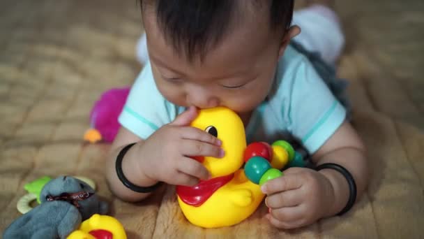 Κινέζικο Μωρό Μασάει Την Κίτρινη Πάπια Στο Κρεβάτι — Αρχείο Βίντεο