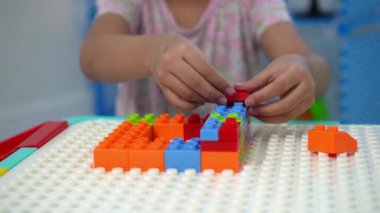 Kızın elini kapat Masada renkli plastik oyuncak bloğu oyna