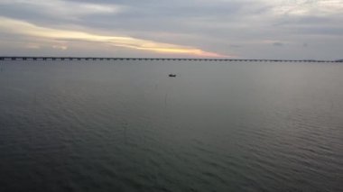 Batu Kawan, Penang, Malezya - 11 Ekim 2021: Gemideki balıkçıya doğru havadan uçmak. Arka plan Penang İkinci Köprüsü denizi aşıyor.