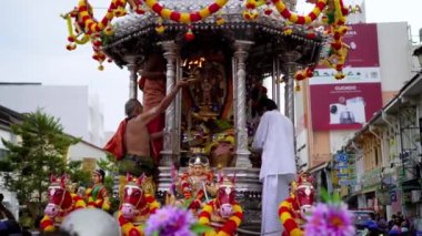 Georgetown, Penang, Malezya - 17 Ocak 2022: Yüz maskeli rahip Thaipusam kutlamaları sırasında gümüş arabanın içindeki Murugan heykelinin önünde gaz lambasını kaldırdı