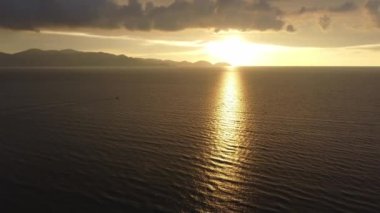 Hava manzaralı tekne dramatik bir günbatımı saatinde denizde hareket ediyor. Arka plan Penang Adası.