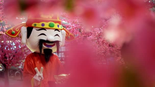 Chinese God Van Welvaart Mascotte Met Wazige Nep Bloesem Bloem — Stockvideo