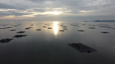 Akşam günbatımında deniz manzaralı kelong balık çiftliği