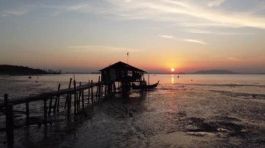 Gün doğumunda alçak gelgit sırasında eski ahşap kulübeye doğru uç.