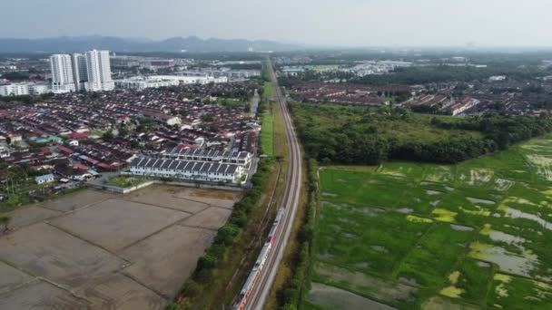 マレーシア ペナン州ブキット メルタジャム 2021年1月21日水田付近の住宅街での空撮列車の移動 — ストック動画