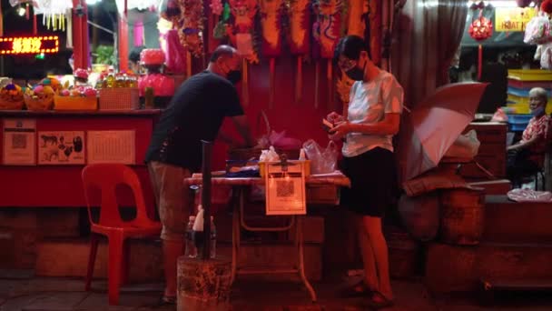 2022年1月31日マレーシア ペナン州ジョージタウン フェイスマスクを持つ中国人が夜間寺院で商品を購入 — ストック動画