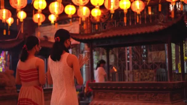 2人の中国人女性信者の背景ビュー中国の寺院でジョススティックで祈る — ストック動画
