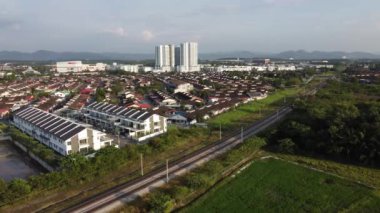 Bukit Mertajam, Penang, Malezya - 21 Ocak 2021: Konut arazisi yakınlarında hızla hareket eden hava manzaralı elektrikli tren