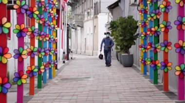 Georgetown, Penang, Malezya - 29 Ekim 2021: Fırıldak ile süslenmiş bir yabancı işçi sokakta yürüyor