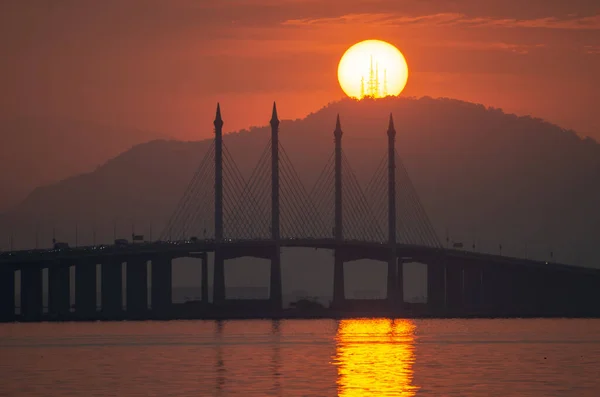ペナン橋と徳君の丘の上の朝の卵黄の日の出 ストック画像