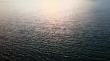 Akşam saatlerinde deniz üzerinde uçan bir uçak.
