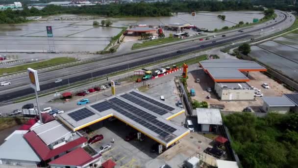 マレーシア ペナン州ブキット メルタジャム2021年10月31日 高速道路脇に太陽光パネルを設置したシェルガソリンスタンドの空中ビュー屋上 — ストック動画
