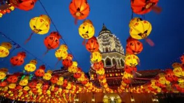 Ayer Itam, Penang, Malezya - 25 Şubat 2022: Alacakaranlık saatinde kırmızı ve sarı Çin fenerinin üzerinden Pagoda tapınağına doğru yavaşça ilerleyin