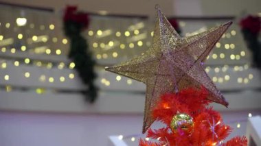 Kırmızı Noel ağacında odak yıldız şekli dekorasyonunu seçin. Güzel yuvarlak ışıklı bokeh arkaplan