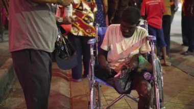 Georgetown, Penang, Malezya - 31 Ocak 2022: Bir adam direksiyon başında oturmuş çocuk insanlardan bağış içeceği bekliyor