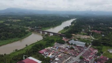 Kuala Kangsar, Perak, Malezya - 04 Mayıs 2022: Sungai Perak Demiryolu Köprüsü Jambatan Victoria 'nın yeşil kırsal bölge yakınlarındaki hava görüntüsü